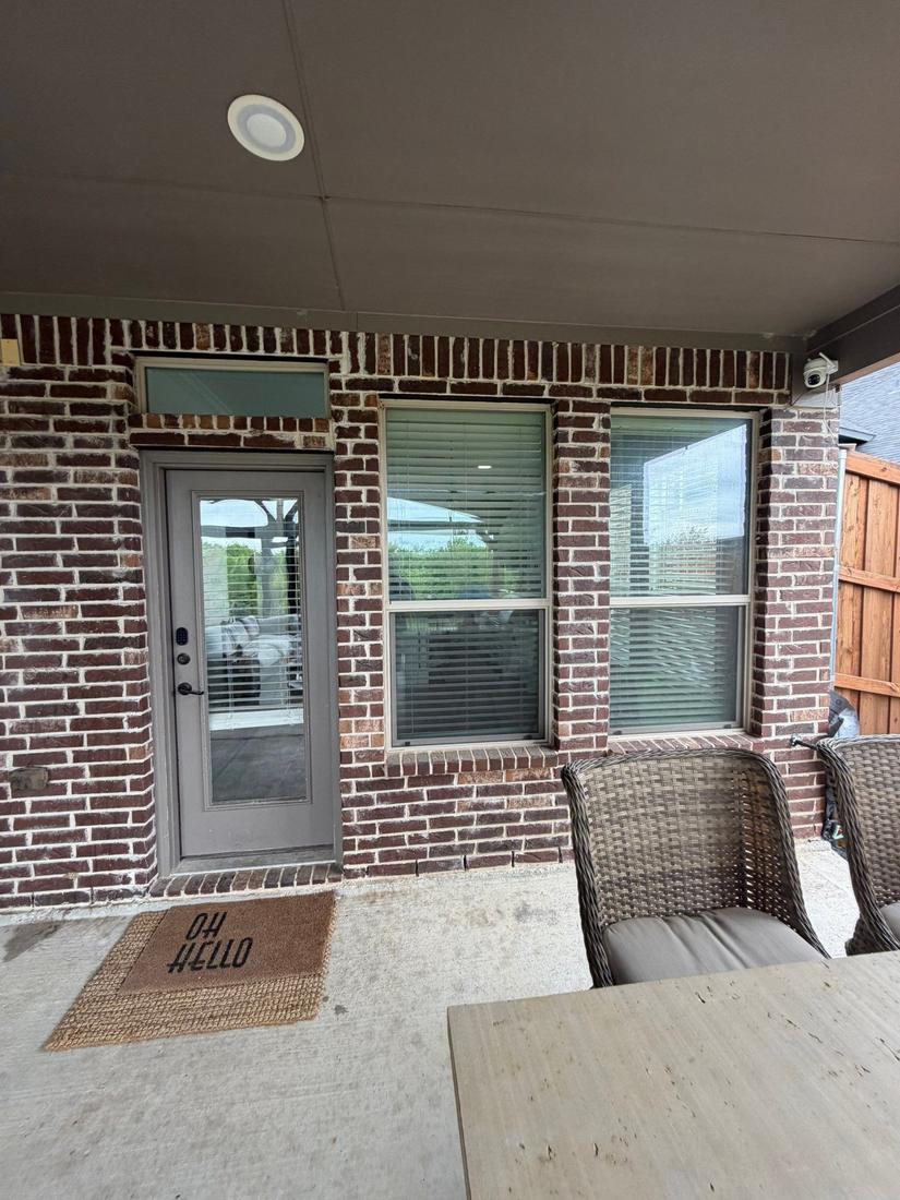 Back patio wall with single door and windows before bifold install