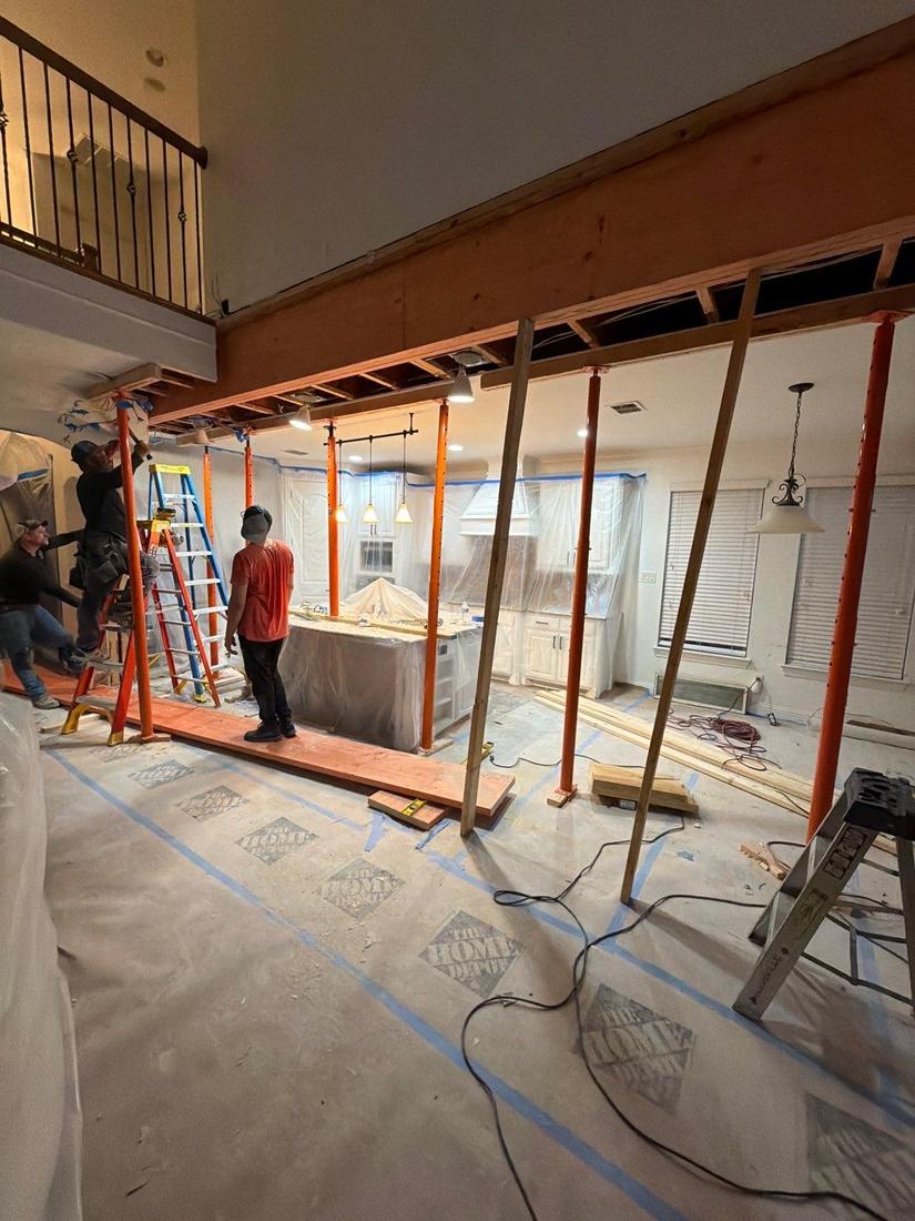Crew removing wall with temporary supports under loft