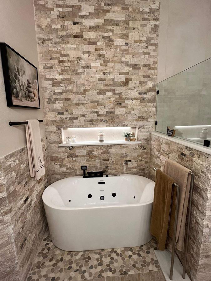 Stacked stone accent wall with soaking tub