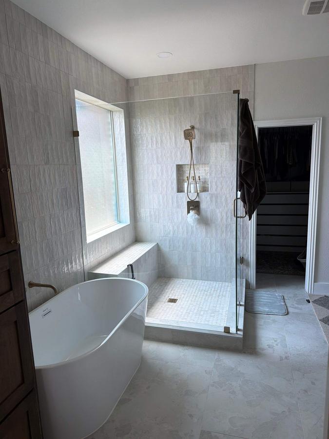 Freestanding tub beside glass shower