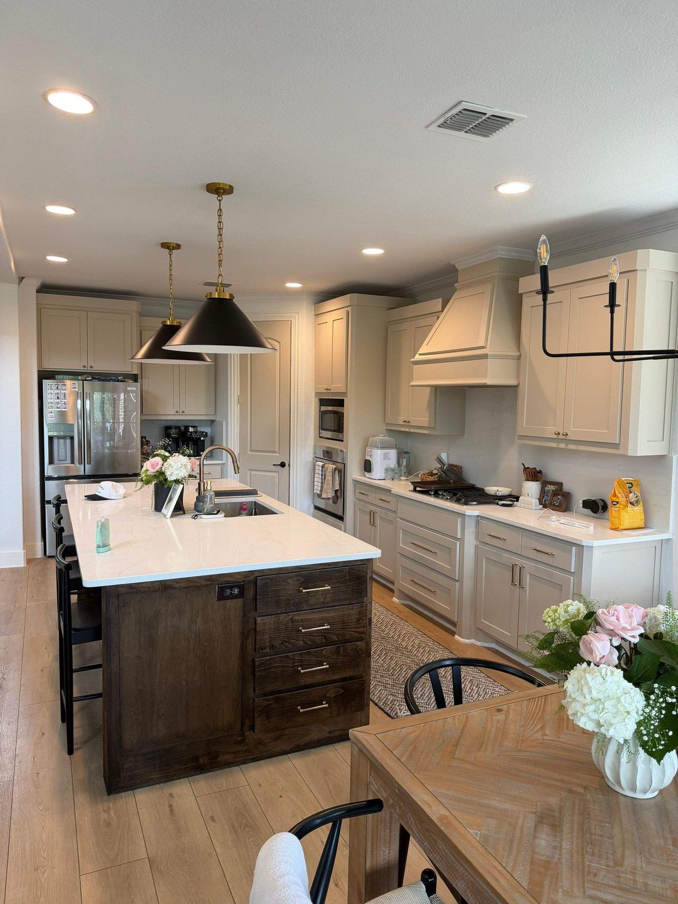 White kitchen with large island and pendant lights