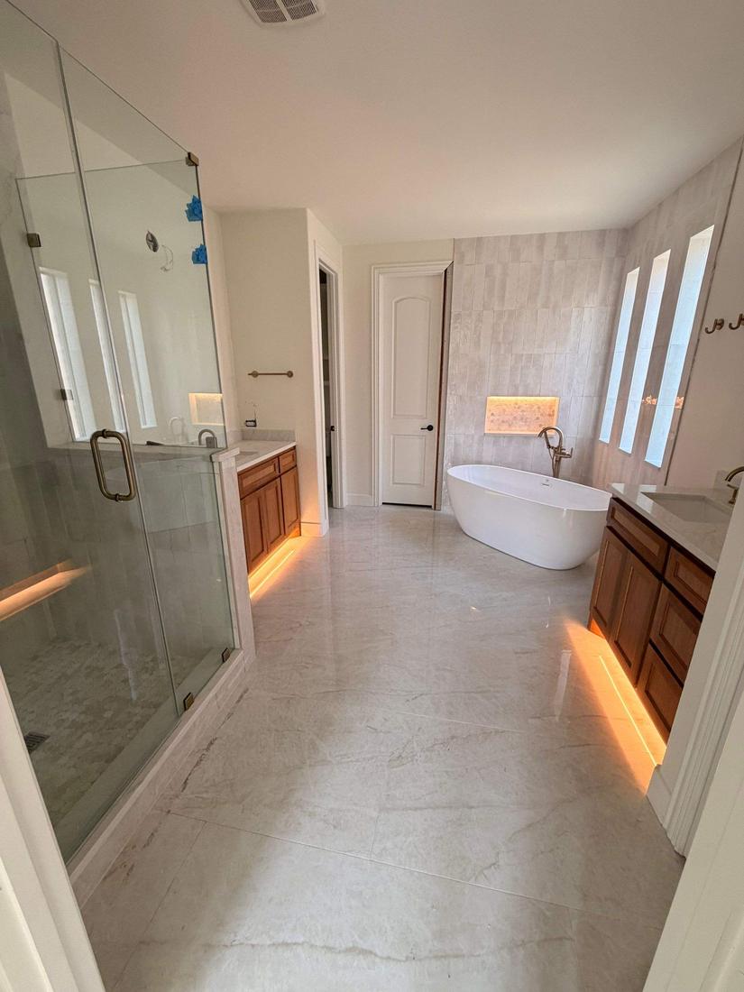 Primary bathroom remodel with freestanding tub, frameless glass shower and lit vanities