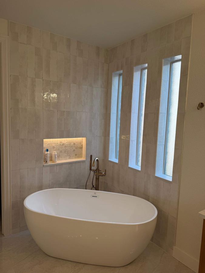 Freestanding tub under tall windows